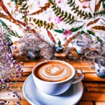 latte art در یک کافه پر از گل و دیوار های چوبی