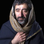 تصویر یک مرد ایرانی ریش دار با زیر پیراهنی کهنه که ناراحت و افسرده است