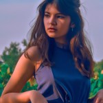 دختری با قیافه غربی و لباسی با رنگ بنفش در طبیعت