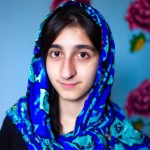 دختر جوان ایرانی با روسری  چشمان سبز به دوربین نگاه میکنه
