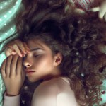 دختری با موهای فرفری که بدن لاغری داره روی یه تخت خوابیده و چشم هاش مثل اهو است