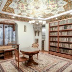 عکس اتاق سر دو نبش با معماری ایرانی و یک میز تحریر و کتابخانه و صندلی با فرش ابریشم رنگ روشن