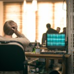 A crowded room and an old computer on the table, a window with light coming from outside, warm lighting, a 30-year-old man with white hair sitting on a chair and thinking about upgrading everything