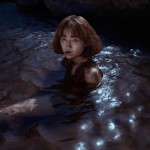 Photo of BTS member Taehyung in the water under the moonlight with a brown dress