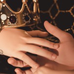 دست یک دختر و پسر که روی یک تاج است
