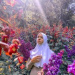یک بانویی که دورش گل باشد در حجاب کامل با چادر در فضای طبیعت