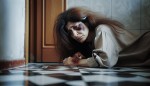 زن همین مرد با حالت آشوفته و صورتی کبود گوشه خانه روی زمین افتاده