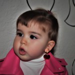 دختر دو ساله ناز با کاپشن صورتی و گوشواره های قلبی صورتب