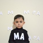 پسری با موهای کوتاه که روی پیراهن مشکی او با سفیدM.Aنوشته شده باشد