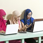 چند نوجوان دختر با حجاب که مشغول کار با موبایل و لپتاپ هستند