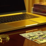 a wooden old nice table with 5 gold coin and 10 sheet 100 dollars and a laptop that have stock market in background , realistic detail ,realistic detail dollars , 4k , HD