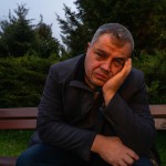 یک غروب ‍پاییزی با هوای ابری یک مرد میانسال خسته روی یک نیمکت