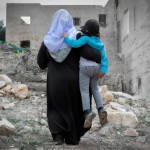 تصویر یک خانم محجبه که در خرابه ها کودکان یتیم فلسطینی را در آغوش گرفته