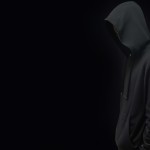 یک پروفایل میخام با بک گراند مشکی از مردی که هودی مشکی پوشیده و رو به دوربین صاف ایستاده و کلاه هودی را روی سرش انداخته و چهرش مشخص نیست