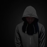 یک پروفایل میخام با بک گراند مشکی از مردی که هودی مشکی پوشیده و رو به دوربین صاف ایستاده و چهرش مشخص نیست