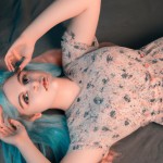 عکس تمام از دختری ۲۱ ساله دراز کشیده بر تخت با مو های حنایی چشمان فیروزه ای لب های صورتی و صورتی بی خش و چروک با لباسی از بالای زانو تا ۱۷ سانتی متر زیر گردن