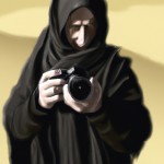 عکاس مرد مذهبی در حال نگاه کردن به دوربین خود در صحرا لباس مشکی رنگ و جفیه طلایی