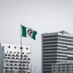 یک شهر مدرن و پیشرفته با پرچم الجزایر که در آن شهر و در میان آپارتمان ها یک پرچم الجزایر قرار گرفته است