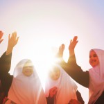 سلام تصویر چند دانش آموز دختر مسلمان و باحجاب ایرانی که دست در دست همدیگر دارند و شادند و به خورشید بزرگ و نورانی نگاه میکنند