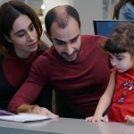 یک آقا و خانم ایرانی به همراه فرزند دخترشان در دفتر بیمه پاسارگاد در حال خرید بیمه عمر