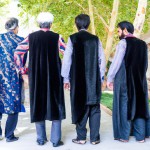 تصویری از چند مرد ایرانی با لباس های بختیاری عربی بلوچی و ترکی که از پشت سر دیده می شوند و نمای کلی بدن را دارند