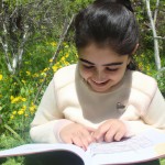 عکس دختر بچه خوشحال ایرانی در طبیعت درحال مطالعه