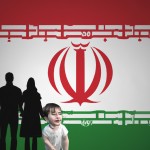 یک کودک با پرچم ایران کنار خانواده