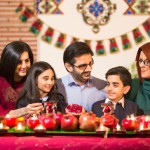 Iranian Family Celebrating Nowruz with Pomegranates and Candles