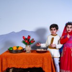 کودکان با لباس های محلی ایرانی با رنگ های مختلف دور سفره هفت سین که در کوهپایه قرار دارن و پشت سرشون کوه دماوند قرار داره