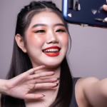 She’s holding a smartphone in selfie mode, talking directly to the viewer with an American accent — friendly, casual, and genuine. Her voice is warm and engaging, with natural pacing and