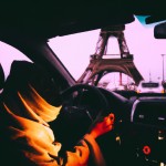 یه زن محجبه با روسری لبنانی در کنار برج ایفل در حال رانندگی بساز