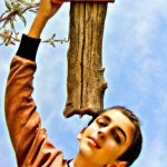 تصویر یک قاب چوبی که به طرف اسمون گرفته شده با دست انسان و روش نوشته دبیرستان مستوره اردلان و عاطفه سیس