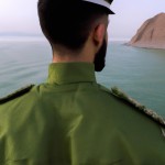 تصویر یک پاسدار  سپاهی با لباس سبز سپاه در تنگه هرمز محاسن بلد موهای کوتاه