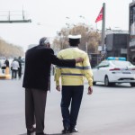 پلیس ایرانی در حال کمک به یک پیرمرد برای عبور از خیابان