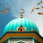 تصویر گنبد فیروزه ای مسجد که داخلش چند ماهی قرمز در حرکت هستند.
