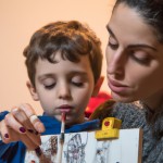 یک پسر بچه که دارد با مادرش نقاشی میکشد