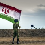 سربازی در میدان جنگ پرچم ایران را برافراشته می کند