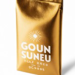 horizontal coffee packaging 250g, bright white background, artistic golden sun rising over coffee beans, brand name "Gold of Sun" in elegant serif font with gold foil effect, minimalist layout, matte finish with spot UV gold accents, realistic product mockup on white surface, professional lighting, ultra detailed,