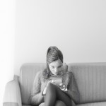 Source my Image, keep face 99.99% Orginal, The photo shows a young woman sitting on a modern armchair, completely engrossed in her own world, looking at her phone. Because the image is black and white, all the tones are softened by shades of gray, creating a gentle atmosphere. Her pose is relaxed, calm, and natural. ---
Pose and Posture
The woman is sitting slightly turned to the side, near the edge of the armchair.
Her left leg is pulled up onto the armchair, the other leg is extended downwards